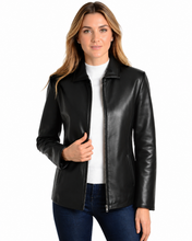 Cargar imagen en el visor de la galería, A woman wearing a black real leather jacket over a white top and dark blue jeans, photographed against a plain white background.
