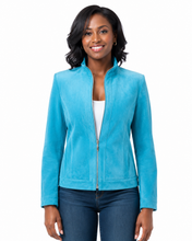 Cargar imagen en el visor de la galería, A woman wearing a bright turquoise blue suede jacket over a white top and dark blue jeans, photographed against a plain white background.
