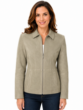 Cargar imagen en el visor de la galería, A woman wearing a light taupe zip-up jacket with a pointed collar and front pockets, paired with dark blue jeans, against a plain white background.
