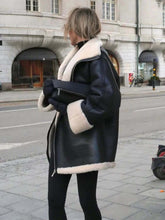 Load image into Gallery viewer, Woman wearing Cozy Chic Bomber Jacket in vegan leather with faux wool details, standing on street.
