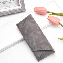 Load image into Gallery viewer, Gray PU leather sunglasses case on white surface, surrounded by pink tulips, ideal for eyewear protection and style.
