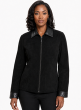 Charger l'image dans la galerie, A woman modeling a black suede-like jacket with black real-leather trim on the collar, cuffs, and front zipper, photographed against a plain light gray studio background.
