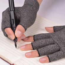 Load image into Gallery viewer, Person wearing compression arthritis gloves writing in a notebook, showcasing pain relief and joint support for daily activities.
