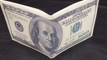 Cargar imagen en el visor de la galería, Folded dollar bill on a dark fabric background
