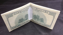 Cargar imagen en el visor de la galería, Folding dollar bill wallet on a dark fabric background
