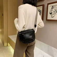 Load image into Gallery viewer, Woman wearing a vintage vegan leather crossbody shoulder bag, black color, showcasing stylish and sophisticated design in indoor setting.
