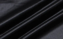 Cargar imagen en el visor de la galería, Black faux leather fabric with a sleek, smooth texture and elegant draping, ideal for creating stylish and sophisticated clothing items.
