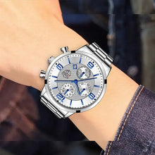 Load image into Gallery viewer, Luxury men&#39;s business watch with sleek silver design and blue accents, worn on a wrist in professional attire.
