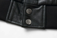 Load image into Gallery viewer, Close-up of REED Men&#39;s Premium Leather Aviator Bomber Jacket, showing black leather texture and branded metal buttons.
