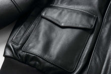Load image into Gallery viewer, Close-up of REED Men&#39;s Premium Leather Aviator Bomber Jacket pocket, showcasing soft durable imported leather and classic design features.
