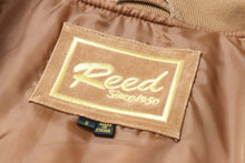 Load image into Gallery viewer, Tag inside REED Men&#39;s Baseball Suede Leather Jacket showing brand label and size. Made in China. Satin lining background.
