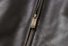 Load image into Gallery viewer, Close-up of REED Men&#39;s New Zealand lambskin leather jacket zipper, showcasing smooth black leather and branded zip for style and quality.
