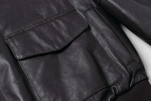Load image into Gallery viewer, Close-up of REED Men&#39;s Premium Leather Aviator Bomber Jacket showing front envelope pocket and soft leather texture.
