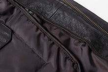 Load image into Gallery viewer, Close-up of the interior lining and stitching of a REED Men&#39;s Premium Leather Aviator Bomber Jacket.
