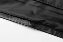 Load image into Gallery viewer, Close-up of REED men&#39;s lambskin leather jacket, black with soft interior fabric and genuine leather texture.
