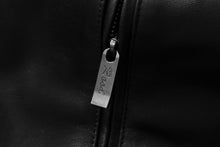 Load image into Gallery viewer, Close-up of REED men&#39;s lambskin leather jacket zipper detail, showcasing craftsmanship and elegance in black.
