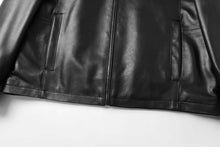 Load image into Gallery viewer, Close-up of black REED men&#39;s lambskin leather jacket, featuring stand-up collar and front zip-up closure.
