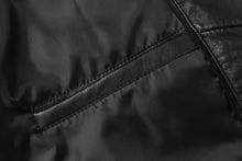 Load image into Gallery viewer, Close-up of genuine lambskin leather texture on REED men&#39;s jacket with zipper detail, showcasing luxury quality.
