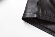 Load image into Gallery viewer, Close-up of black genuine lambskin leather jacket sleeve with soft lining, showcasing premium stitching and material quality.
