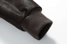 Load image into Gallery viewer, Close-up of sleeve cuff on REED Men&#39;s Baseball Suede Leather Jacket, showcasing smooth texture and ribbed design.
