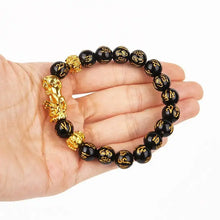 Load image into Gallery viewer, Feng Shui wealth bracelet with black beads and gold Pixiu charm, designed to attract prosperity and luck.

