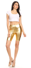 Charger l&#39;image dans la galerie, Model wearing shiny metallic gold bike shorts with white crop top, stretchy unisex design, made in USA.
