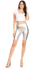 Charger l&#39;image dans la galerie, Model wearing shiny metallic bike shorts, stretchy unisex design, paired with a white crop top and heels, showcasing the fit and style.
