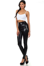 Charger l&#39;image dans la galerie, Model wearing shiny liquid metallic high waist stretch leggings, black, designed and made in USA, paired with white top and heels.
