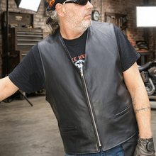 Load image into Gallery viewer, Man wearing a leather biker vest in a garage setting with motorcycle and lighting equipment.
