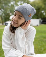 Load image into Gallery viewer, Woman wearing NEW HAAKWEAR H-Stitch Cuffed Beanie - Designed and Made in USA (Patent Pending Design) - Koala Gray outdoors.
