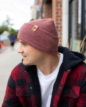 Charger l&#39;image dans la galerie, Man wearing NEW HAAKWEAR H-Stitch Cuffed Beanie in Rusty Burgundy, designed and made in USA, outdoors in urban setting.
