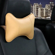 Load image into Gallery viewer, PU leather car neck pillow on car seat, providing head pain relief and comfort during drives with stylish and functional design.
