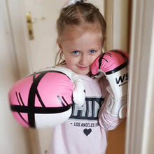 Load image into Gallery viewer, Young girl wearing pink and white boxing gloves, smiling and ready for training.
