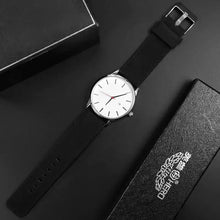 Charger l&#39;image dans la galerie, Elegant black leather quartz watch with a white dial, featuring vegan leather strap, displayed with branded black packaging.
