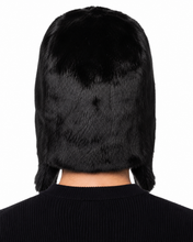 Load image into Gallery viewer, Rear view of a person wearing a black faux fur hat with ear flaps and a ribbed black top, shown against a plain white background.
