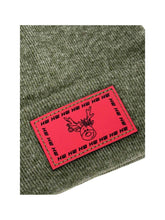 Cargar imagen en el visor de la galería, Reindeer Limited Edition Christmas Beanie in festive green knit with Ho Ho Ho label, part of Haakwear&#39;s 2025 collection.
