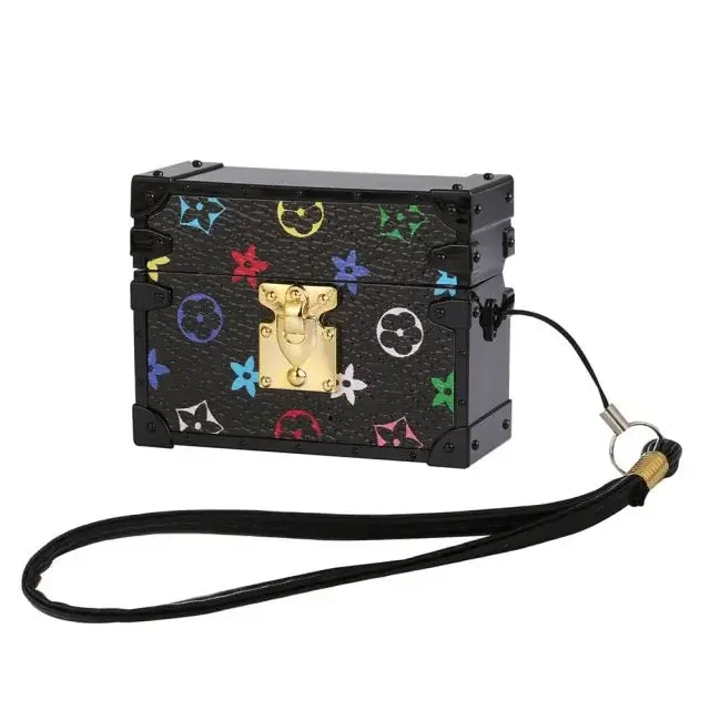 Luxury patterned black case with gold clasp and detachable strap for tech accessories.