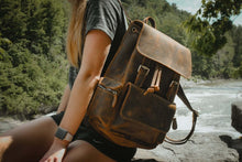 Load image into Gallery viewer, Woman outdoors with The Hagen Backpack | Vintage Leather Backpack in rustic setting
