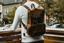 Load image into Gallery viewer, The Hagen Backpack | Vintage Leather Backpack showcased in outdoor setting, emphasizing genuine cowhide leather quality and style.
