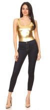 Load image into Gallery viewer, Woman wearing a gold metallic leotard top paired with dark denim jeans, standing against a white background.
