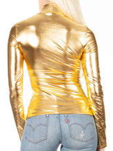 Charger l&#39;image dans la galerie, Back view of woman wearing a metallic gold mock neck turtleneck long sleeve top paired with light blue jeans.
