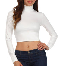 Load image into Gallery viewer, Model wearing a white matte liquid mock neck turtleneck long sleeve crop top, paired with dark jeans, front view.

