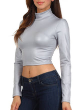Load image into Gallery viewer, Woman wearing silver matte liquid mock neck turtleneck crop top with long sleeves, paired with blue jeans, made in USA.
