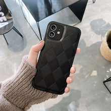 Cargar imagen en el visor de la galería, Hand holding black retro vegan leather phone case with diamond pattern, showcasing stylish design and comfortable grip.
