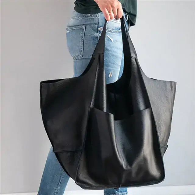 Person holding a black retro luxury shoulder bag made of vegan PU leather, showcasing its spacious design and casual elegance.
