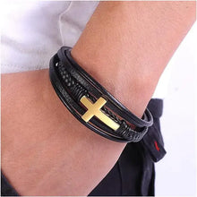 Load image into Gallery viewer, Person wearing vegan leather cross bracelet, perfect heartfelt gift for loved ones, shown in stylish black and gold design.
