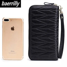 Load image into Gallery viewer, Black leather female travel purse with elegant design next to a smartphone, showcasing its compact size and chic style.
