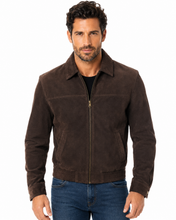 Charger l'image dans la galerie, A man wearing a dark brown suede zip-up jacket over a black shirt and blue jeans, photographed against a plain white background.
