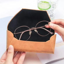 Load image into Gallery viewer, Person placing eyeglasses into a stylish PU leather sunglasses case, highlighting practical eyewear protection.
