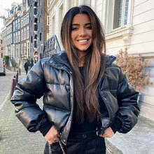 Load image into Gallery viewer, Woman wearing a black winter thick PU leather coat, smiling outdoors on a city street, showcasing cozy and stylish fashion.
